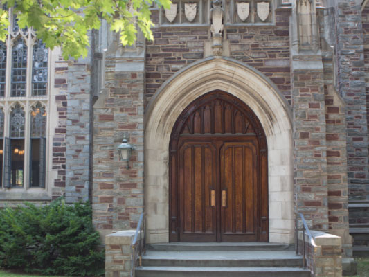 Large wooden door with an arched limestone entry